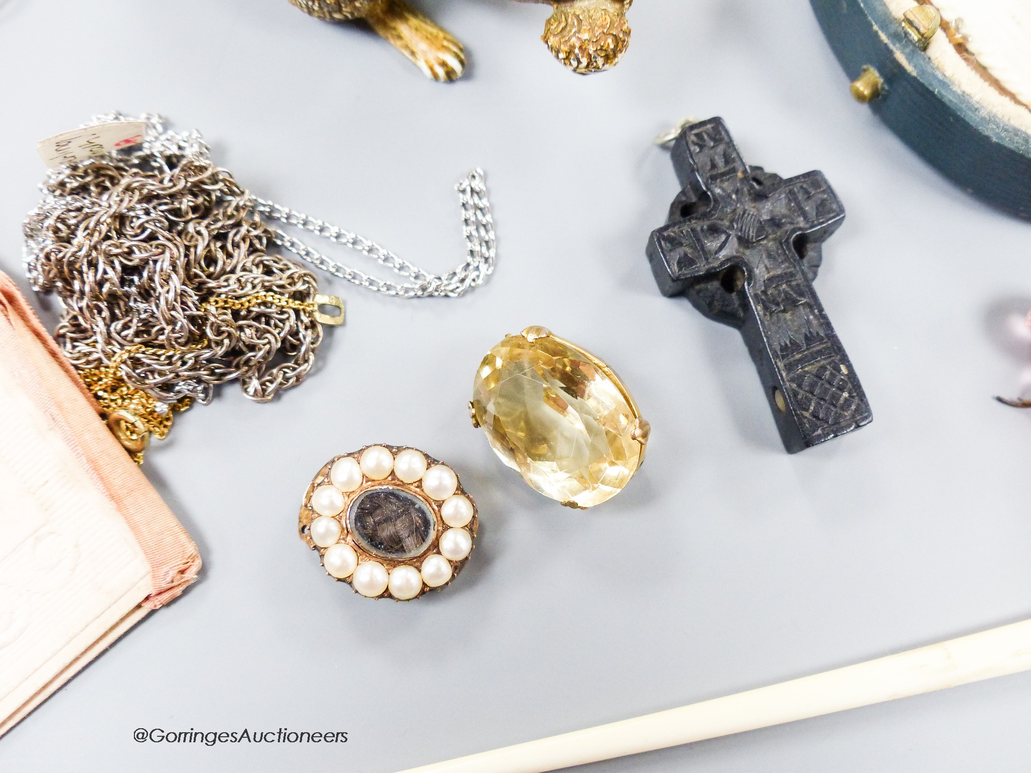 A small group of assorted bijouterie including base metal and composite poodle pin cushion, a white metal and enamel locket on sterling chain, a citrine brooch(lacking pin), a slit pearl set yellow metal mourning clasp e